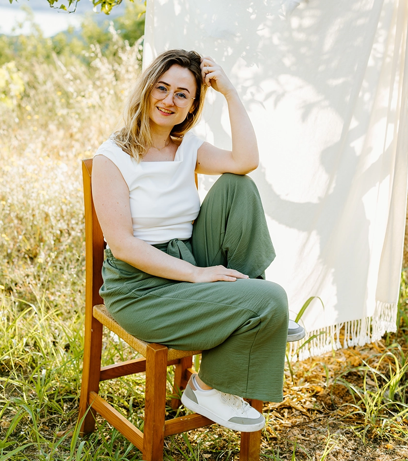 Chrissi Eschelmueller, Coach für Resilienz und Selbstführung, lächelt in die Kamera – Portrait im Freien mit natürlichem Hintergrund
